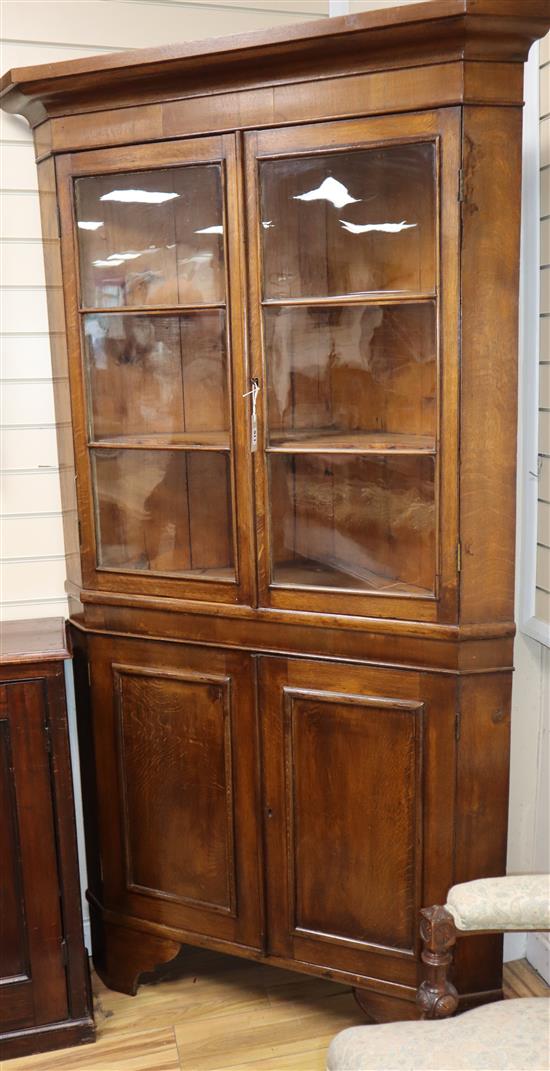 An early 19th century mahogany banded oak standing corner cupboard W.106cm